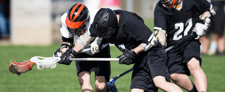 lacrosse players blocking a defensive move